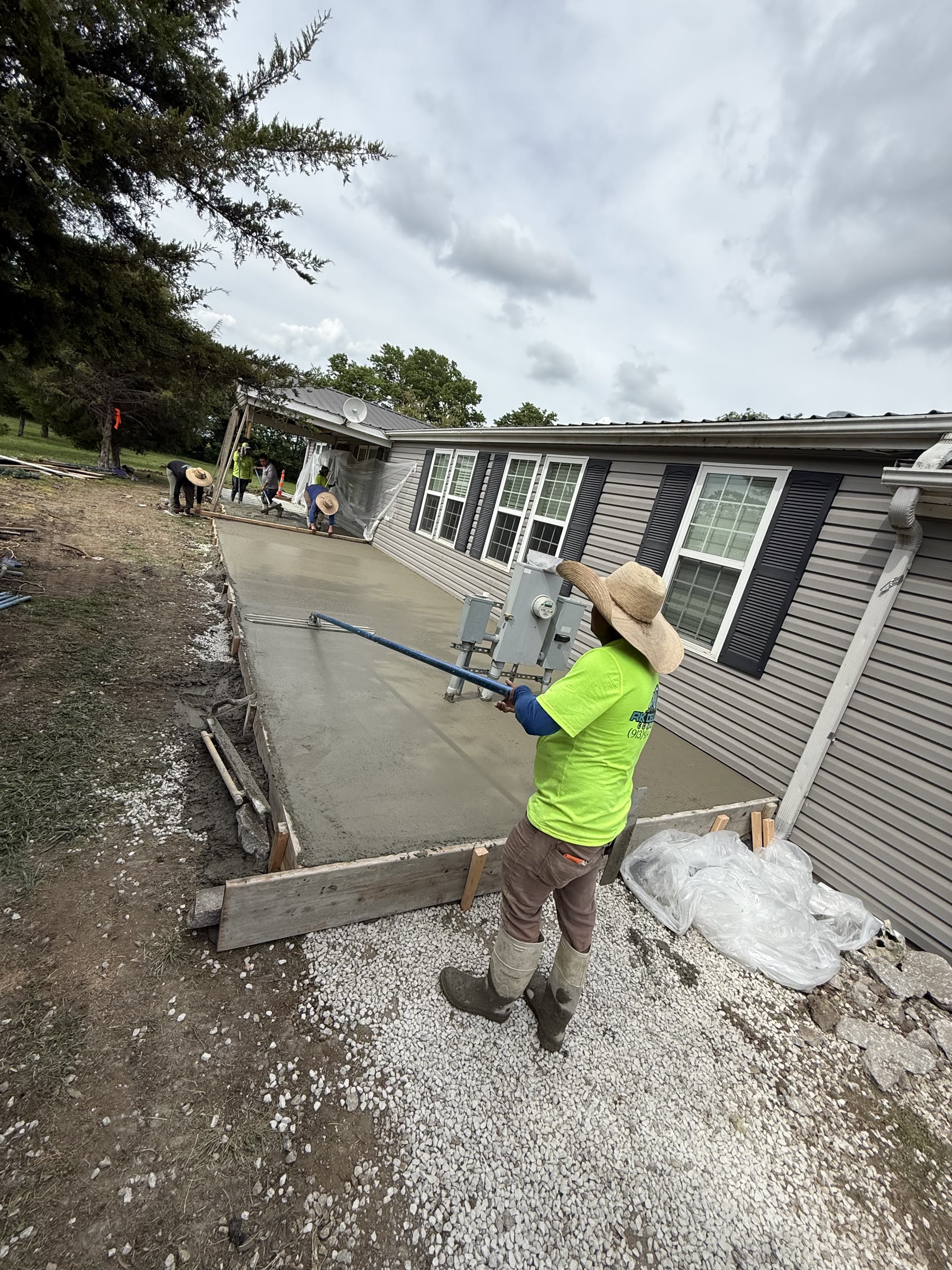 RK Deluxe Concrete crew member hand-finishing a freshly poured concrete slab