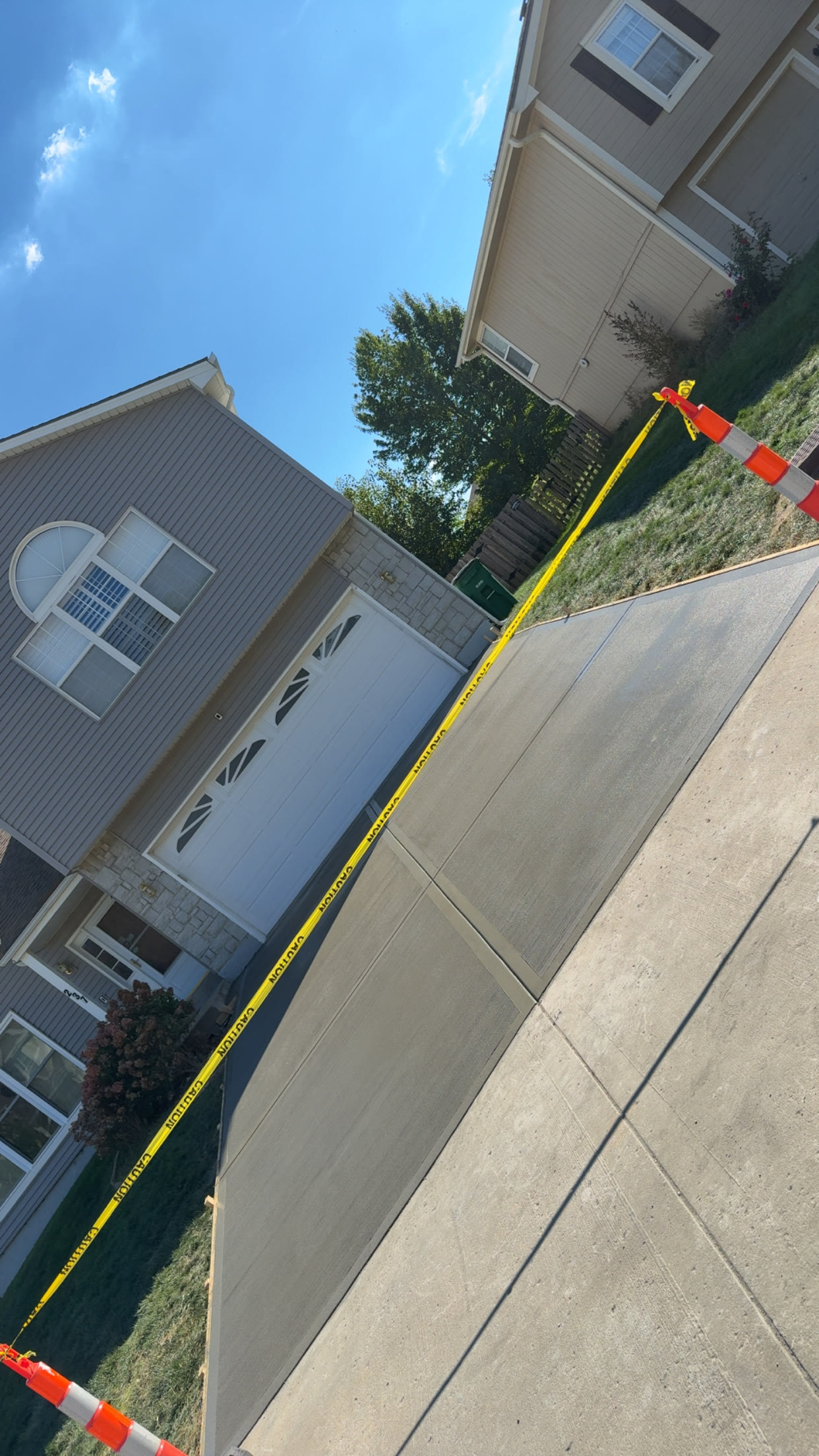 New concrete driveway leading to a townhome garage